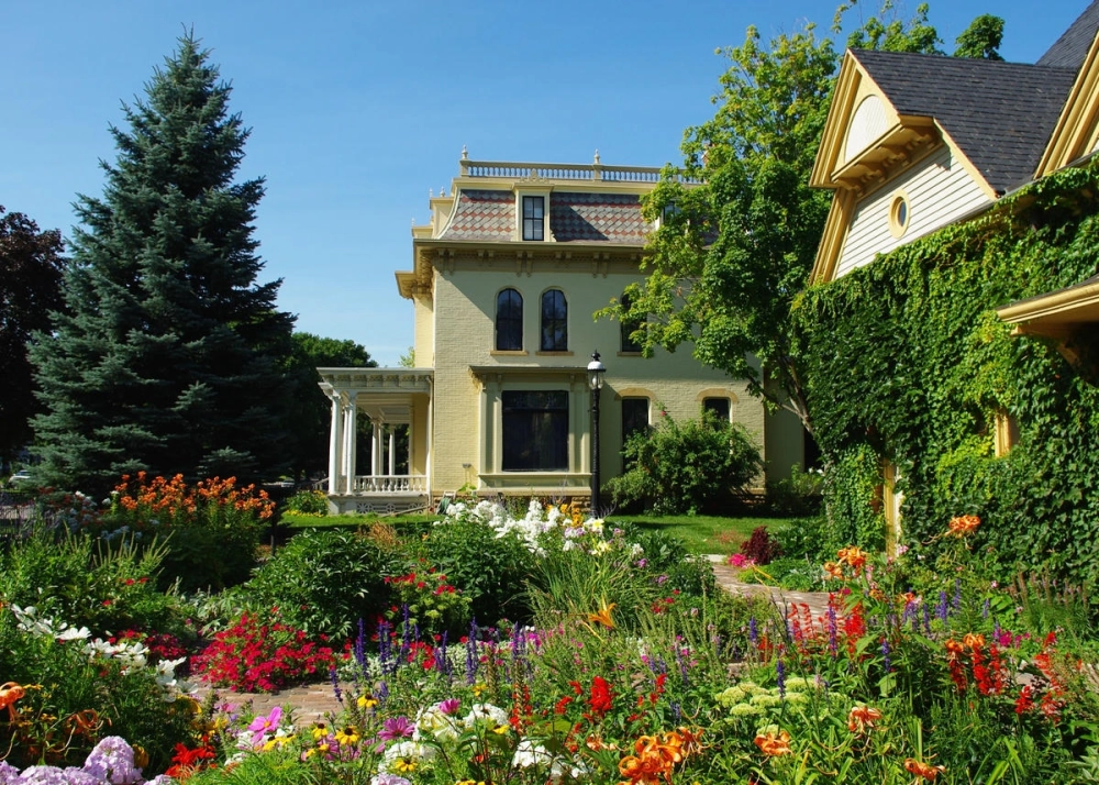 Cổng vào biệt thự nhà vườn 2 tầng đẹp được trang trí nhiều hoa tươi