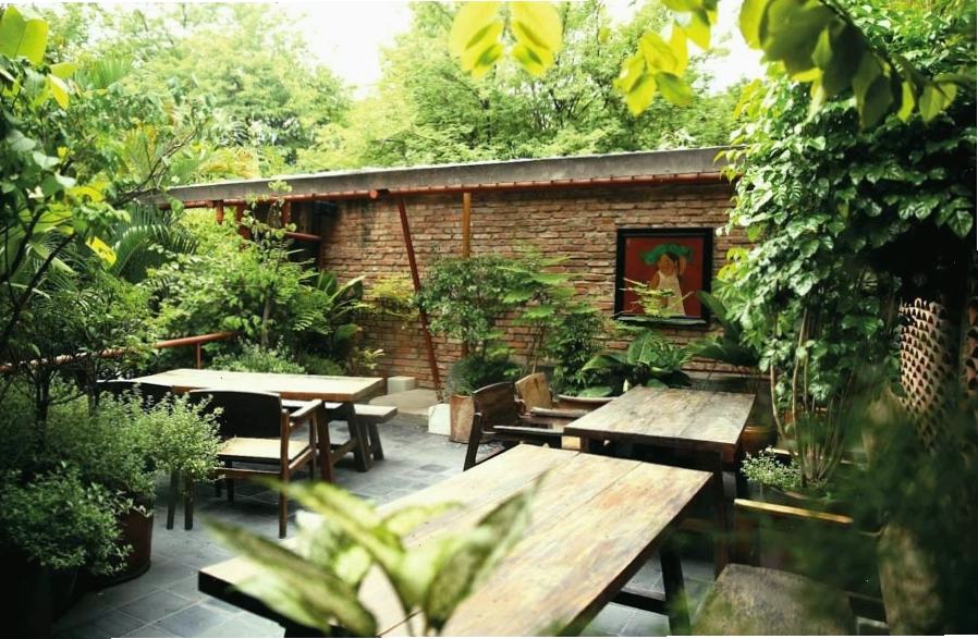 Cảnh quan nhà hàng sân vườn với nhiều cây xanh và hồ nước nhỏ
