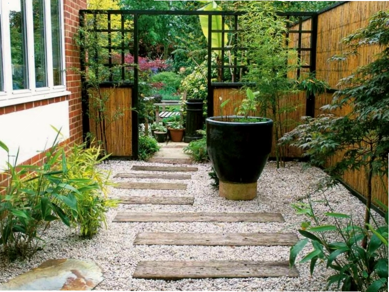 Sân vườn nhà ống với cây xanh bao quanh lối đi